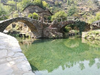 Arch bridge over river by old building