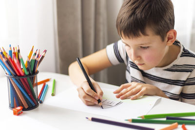 Boy drawing on book at home