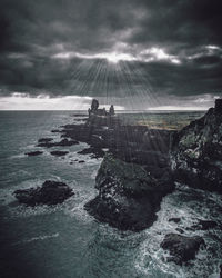 Scenic view of rocks on sea against sky