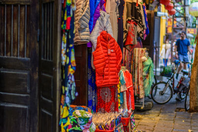 Multi colored clothes hanging on street at market stall