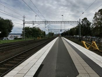 Empty railroad station platform against sky