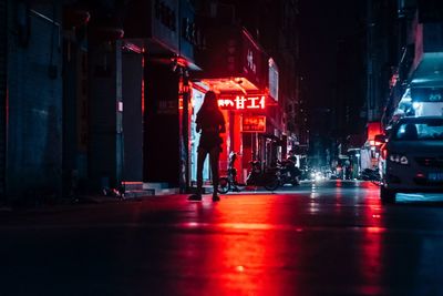 People on illuminated city street at night