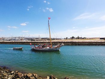 Sailboats moored in sea against sky