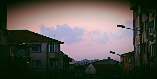 Low angle view of buildings against sky at sunset