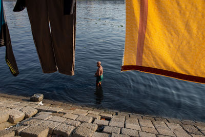A man taking a bath on polluted buriganga river water in dhaka bangladesh.