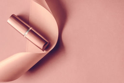 Cropped hand of woman with nail polish against pink background