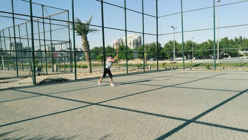 Man playing basketball court against clear sky