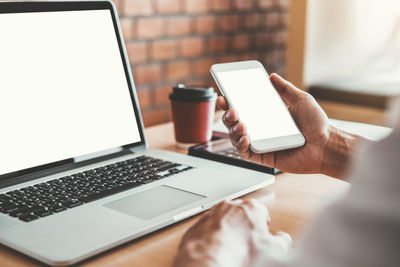 Midsection of man using laptop on table