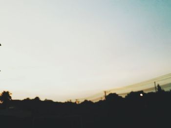 Silhouette landscape against clear sky during sunset