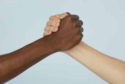 Close up of holding hands against blue background