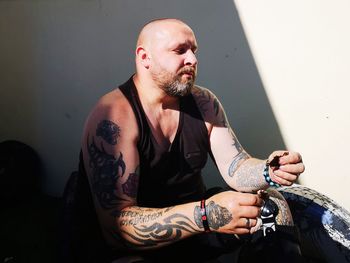 Man looking away while sitting on wall