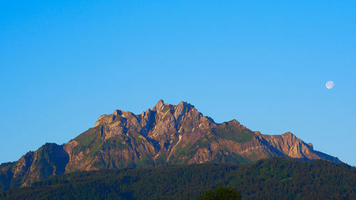 Scenic view of rocky mountains against clear blue sky