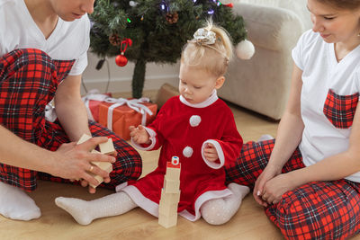 Midsection of woman holding christmas tree at home