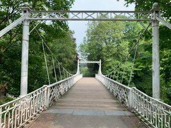 Footbridge amidst trees in forest