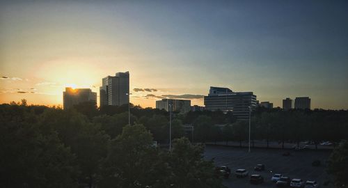 Buildings in city against sky during sunset