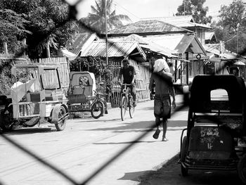 Men on street seen from chainlink fence