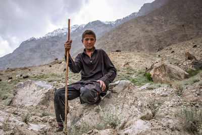Portrait of man sitting on rock
