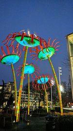 Low angle view of illuminated carousel against sky at night
