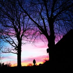 Silhouette trees on landscape against romantic sky at sunset