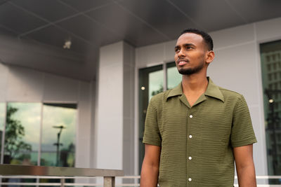 Young man standing against wall