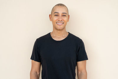Portrait of young man standing against white background