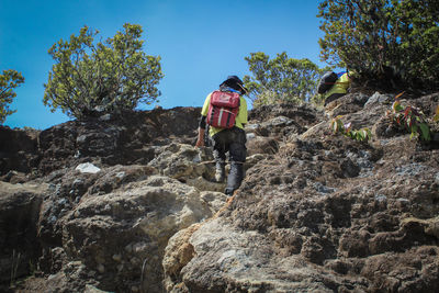 Rear view of man walking on rock