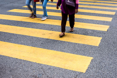 Low section of woman walking on road