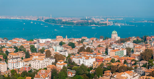 High angle view of townscape by sea against sky