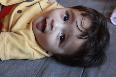 High angle view of cute boy lying on bed at home