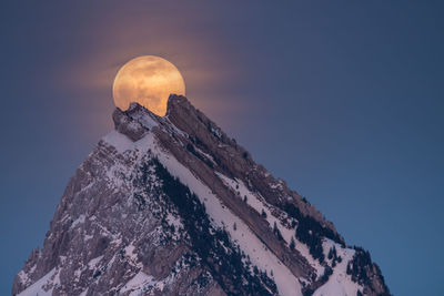 Low angle view of snowcapped mountain against sky during sunset