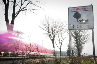 Information sign on field against sky