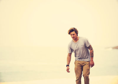 Portrait of young man standing against sky