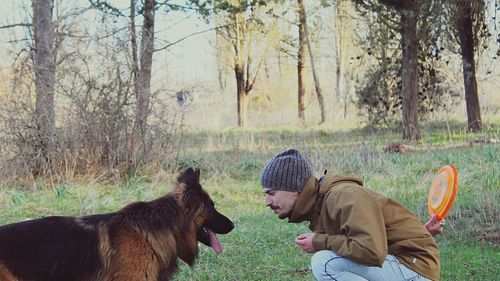 Man playing with dog in forest