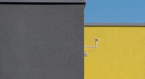 Low angle view of yellow wall against building