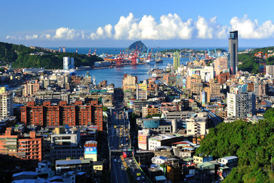 High angle view of cityscape by sea against sky