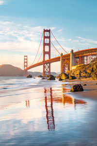 Golden gate bridge over river against sky