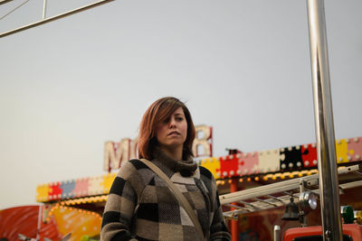 Portrait of young woman standing against sky