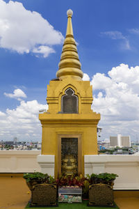 Low angle view of gold stupas against sky