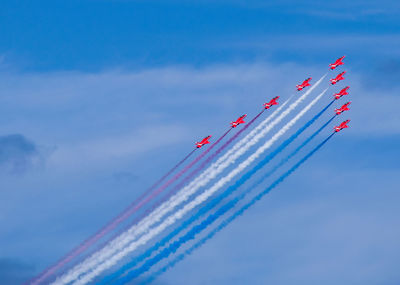 Low angle view of airplane flying against blue sky