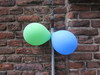 Close-up of balloons against brick wall