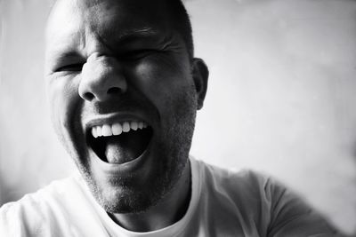 Close-up of happy man screaming at home