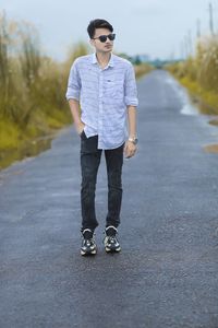 Portrait of young man standing on road