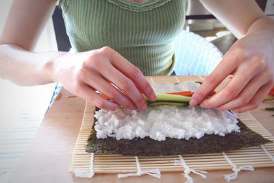 Midsection of woman preparing food on cutting board