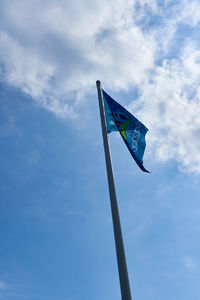 Low angle view of flag against blue sky