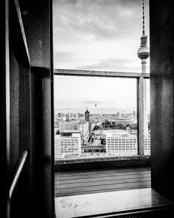 Fernsehturm in city seen through window