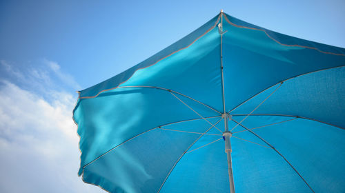 Low angle view of umbrella against blue sky