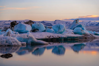 Scenic view of frozen lake against sky during sunset