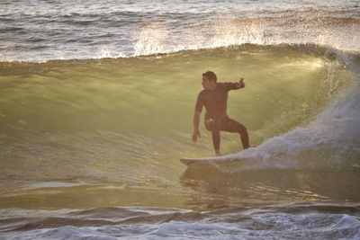 Full length of man surfboarding in sea