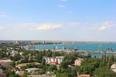 High angle view of townscape by sea against sky