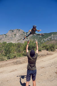 Father throws son up in the mountains in the summer in the crimea